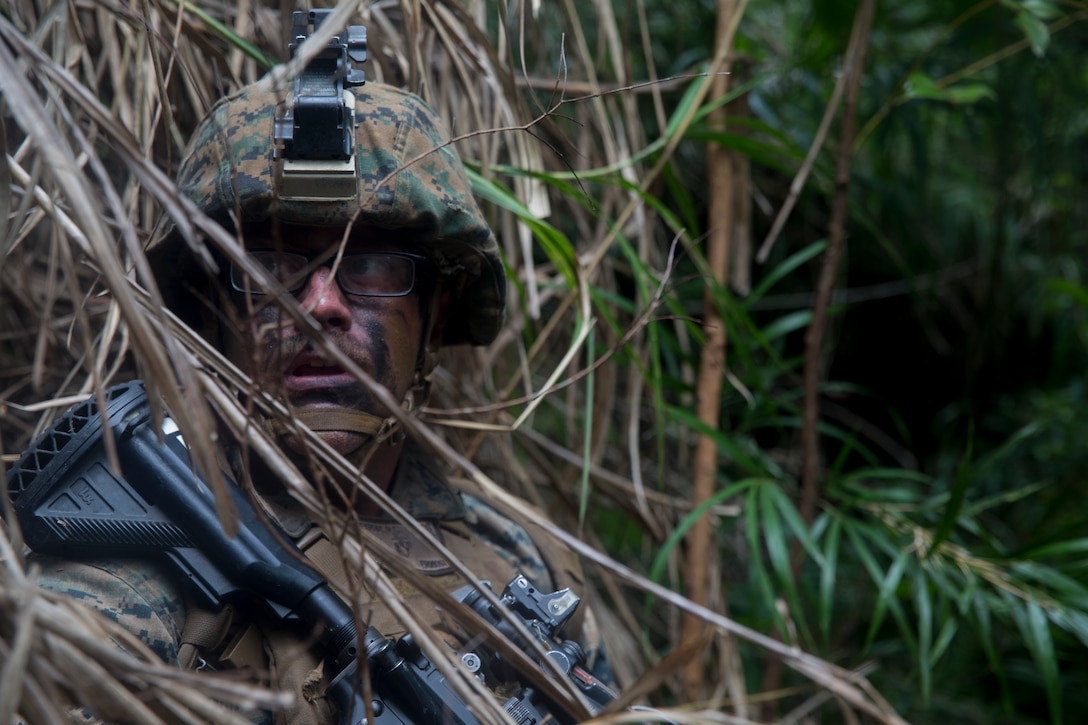 Lance Cpl. Ryan Revout, a native of Ottawa, Illinois and a rifleman with Echo Company, Battalion Landing Team, 2nd Battalion, 5th Marines, seeks cover during a mechanized assault on Combat Town as part of the 31st Marine Expeditionary Unit’s MEU Exercise, Central Training Area, Okinawa, Japan, June 28, 2018. Marines and Sailors with Echo Company performed the final training event of MEUEX, an assault launched from Camp Schwab and targeting Combat Town, part of Okinawa’s Central Training Area. Marines with Echo Company, the mechanized assault element with BLT 2/5, partner with AAV crews to perform raids and assaults launched from the sea. MEUEX is the first in a series of three pre-deployment training events that prepare the 31st MEU to deploy at a moment’s notice. The 31st MEU, the Marine Corps’ only continuously forward-deployed MEU, provides a flexible force ready to perform a wide-range of military operations.