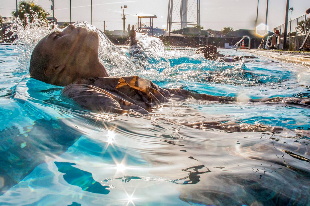 A marine swims in a pool.