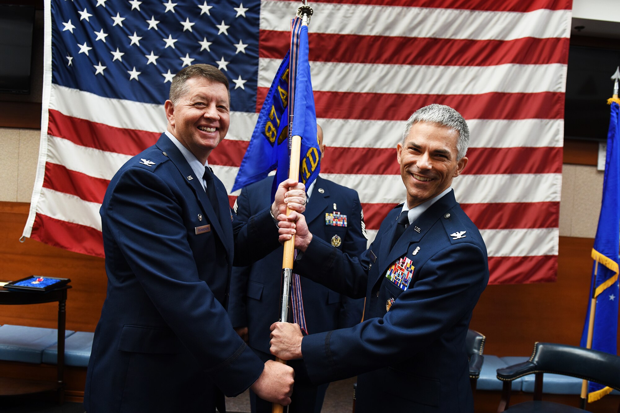 U.S. Air Force Col. Neil Richardson, 87th Air Base Wing and Joint Base McGuire-Dix-Lakehurst commander, passes a guide on to Air Force Col. Jason Lennen, 87th Medical Group commander during the 87th MDG change of command ceremony on Joint Base MDL N.J., June 26, 2018. Lennen assumed command from Air Force Col. Mike Foutch. (U.S. Air Force photo by Airman 1st Class Zachary Martyn)