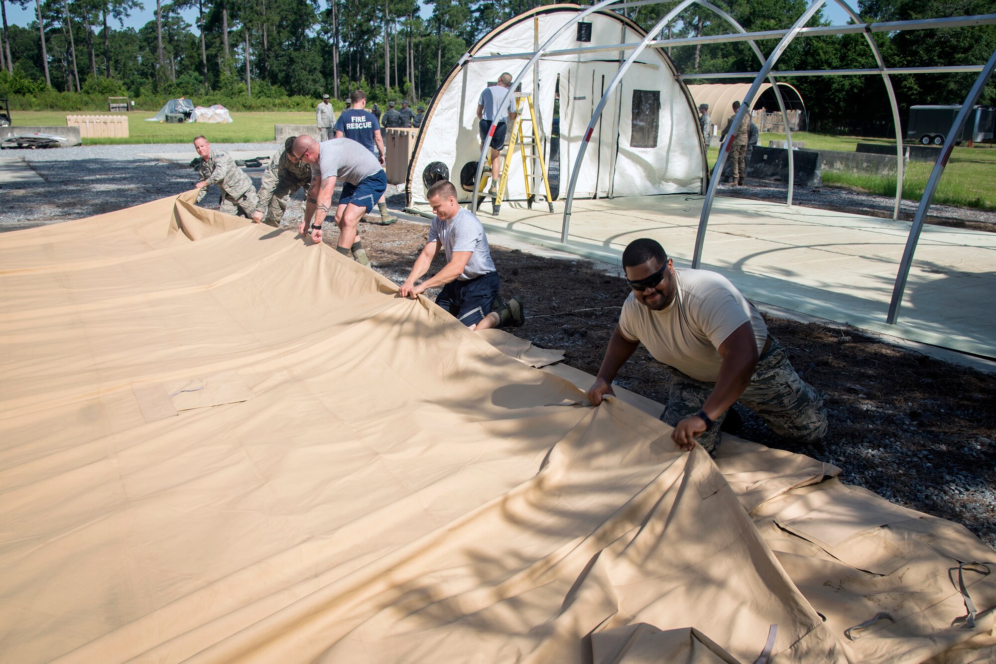Airmen from the 23d Civil Engineer Squadron, fold up a tarp during a chemical, Biological, Radiological, Nuclear and Explosive (CBRNE) Olympics, June 21, 2018, at Moody Air Force Base, Ga.  Moody’s first CBRNE Olympics, were held to further Airmen’s overall knowledge on all of the aspects of CBRNE through a new method that was meant to establish a sense of competition and camaraderie. (U.S. Air Force photo by Airman 1st Class Eugene Oliver)