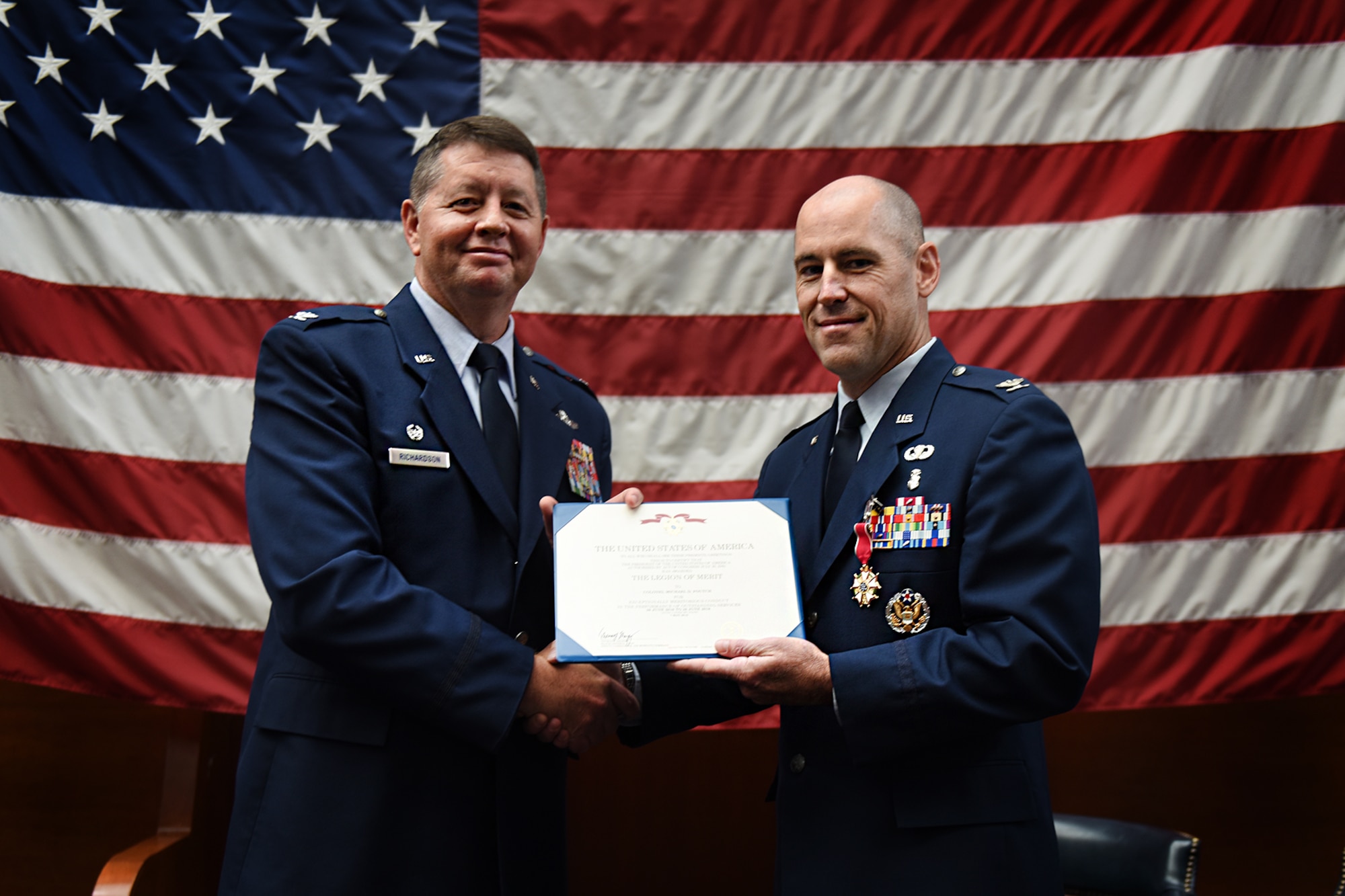 U.S. Air Force Col. Neil Richardson, 87th Air Base Wing and Joint Base McGuire-Dix-Lakehurst commander, poses with Air Force Col. Mike Foutch during the 87th Medical Group change of command ceremony on Joint Base MDL, N.J., June 26, 2018. During the ceremony Foutch relinquished command of the 87th MDG to Air Force Col. Jason Lennen. (U.S. Air Force photo by Airman 1st Class Zacahry Martyn)