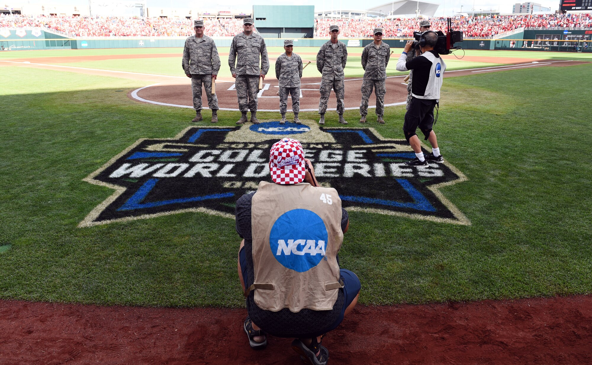 Airmen stand at home plate of TD Ameritrade Park for game one of the National Collegiate Athletic Association Men’s College World Series Omaha, Nebraska, June 26, 2018.