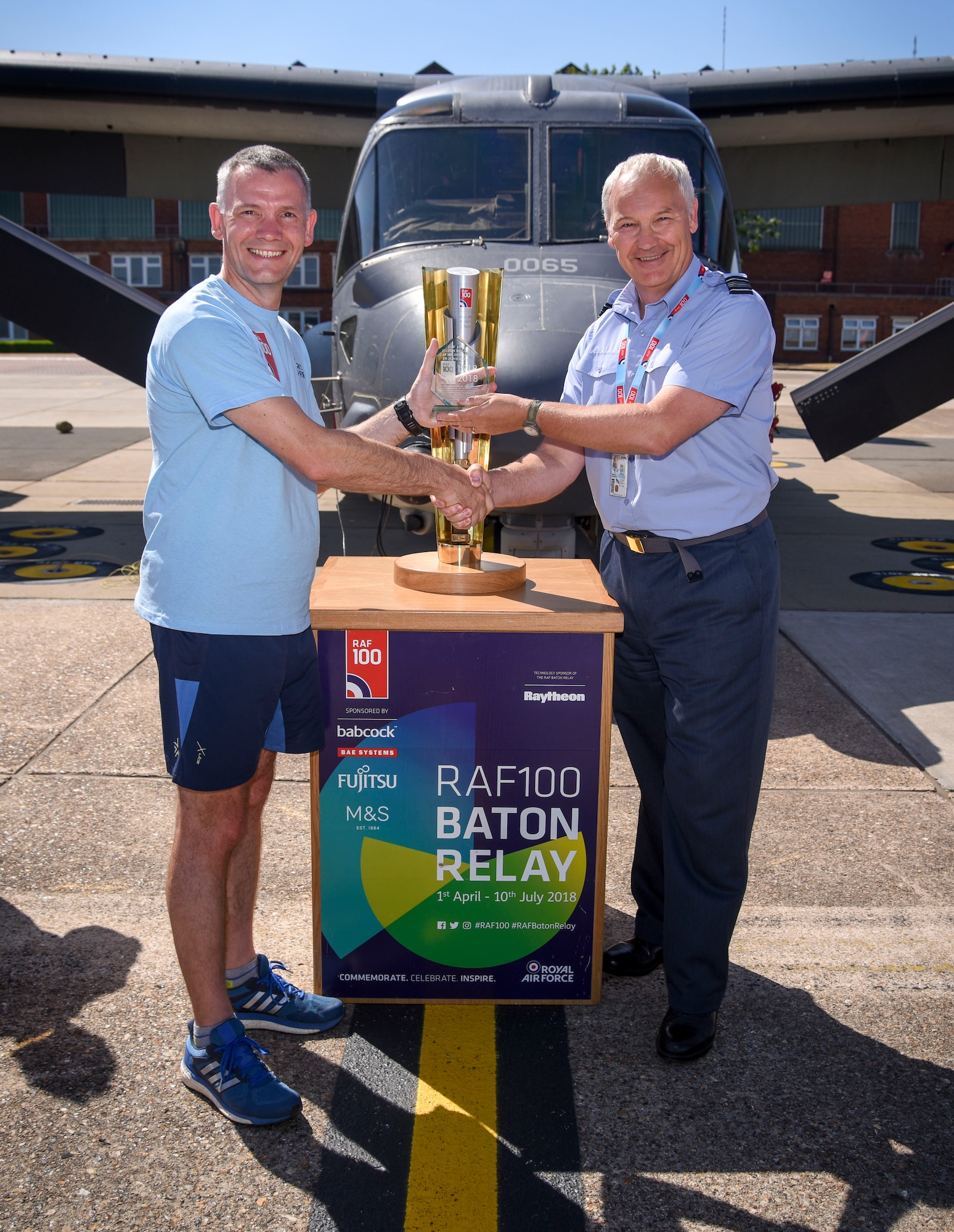 Royal Air Force Sqn. Ldr. Duncan Arnold, RAF Liaison Officer,  presents the Royal Air Force baton relay team a plaque for completing their part in the RAF 100 Baton Relay, during their visit to RAF Mildenhall, England, June 29, 2018. The RAF is celebrating 100 years and are visiting 100 bases around the U.K. in 100 days in celebration of 100 years of the RAF. (U.S. Air Force photo by Senior Airman Christine Groening)