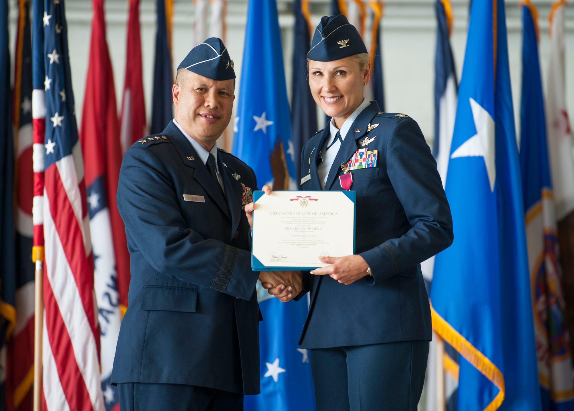 U.S. Air Force Lt. Gen. GI Tuck, 18th Air Force commander, presents a Legion of Merit to Col. April Vogel, the 6th Air Mobility Wing commander before her change of command ceremony at MacDill Air Force Base, Fla., June 29, 2018.