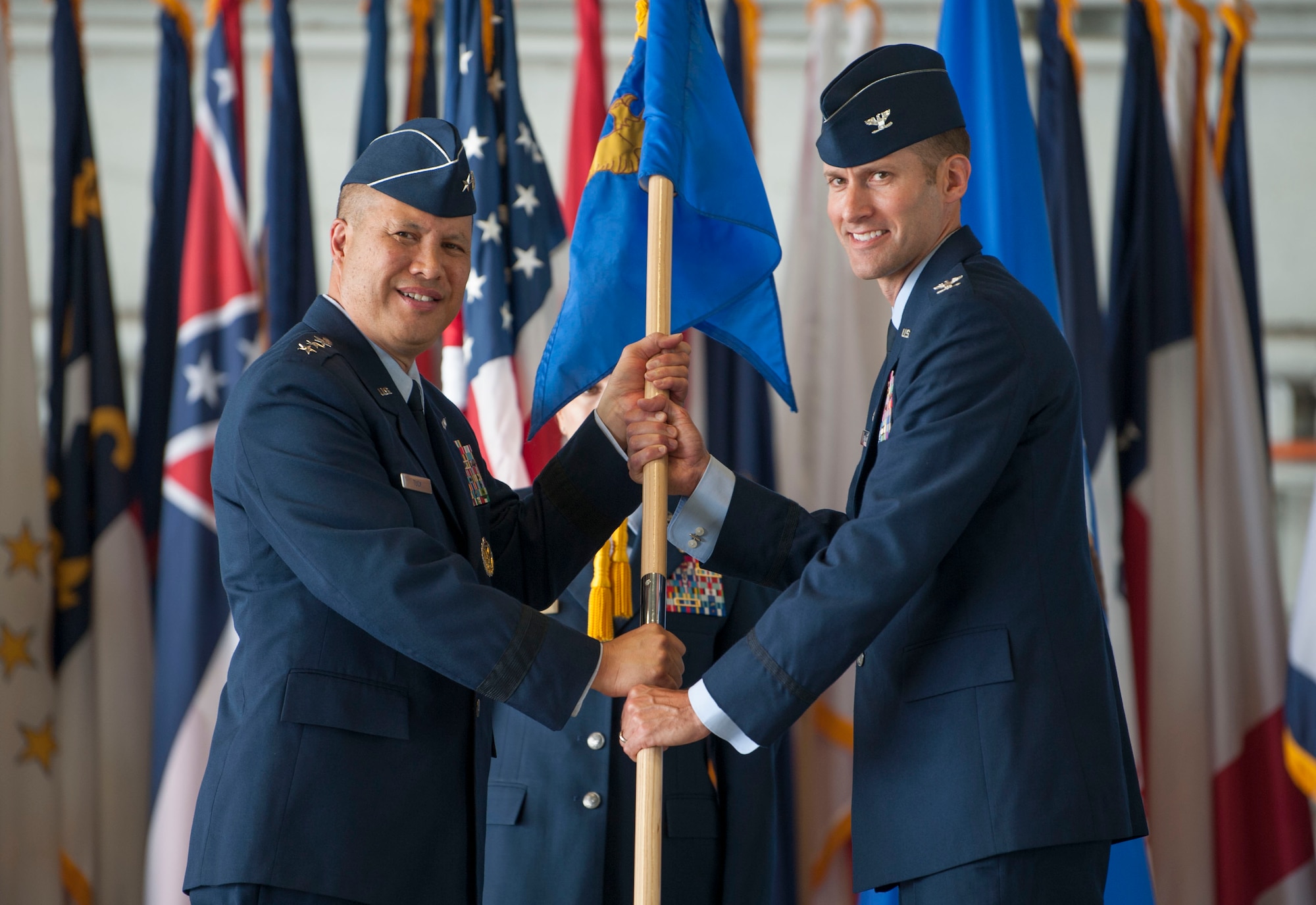 U.S. Air Force Lt. Gen. GI Tuck, commander of the 18th Air Force, passes the 6th Air Mobility Wing guidon to incoming commander, Col. Stephen Snelson, during the wing change of command ceremony at MacDill Air Force Base, Fla., June 29, 2018.
