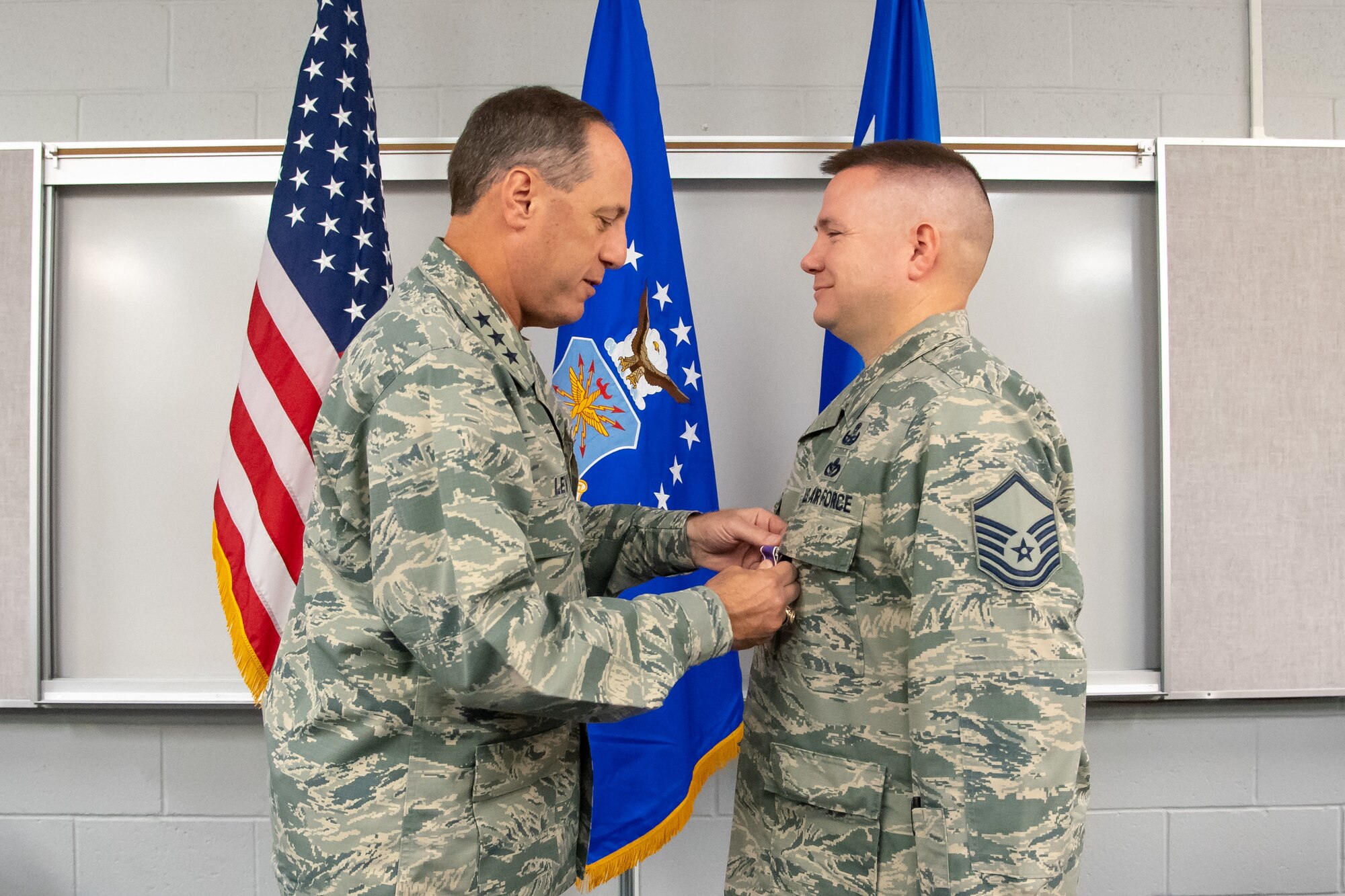Explosive Ordnance Technician Master Sgt. Joseph Upton recieves his second Purple Heart from Air Force Sustainment Center Commander Lt. Gen. Lee K. Levy II June 22, 2018, at Hill Air Force Base, Utah. Upton was injured in 2013 while supporting an Army unit in Afghanistan. He recieved his first Purple Heart in 2005 while deployed to Iraq. (U.S. Air Force photo by R. Nial Bradshaw)