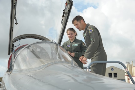 Maj. Justin Stimets, 560th Flying Training Squadron instructor pilot, speaks with Megan Foster aboard a T-38 Talon during her “Pilot for a Day” orientation June 26, 2018, at Joint Base San Antonio-Randolph, Texas.  The "Pilot for a Day" program invites children of all ages, military or civilian, to be guests of the 12th Flying Training Wing and its flying squadrons for an entire day. Doing so, the 12th FTW strives to give each child a special day and a break from the challenges they may face.  (U.S. Air Force photo by Joel Martinez/Released)