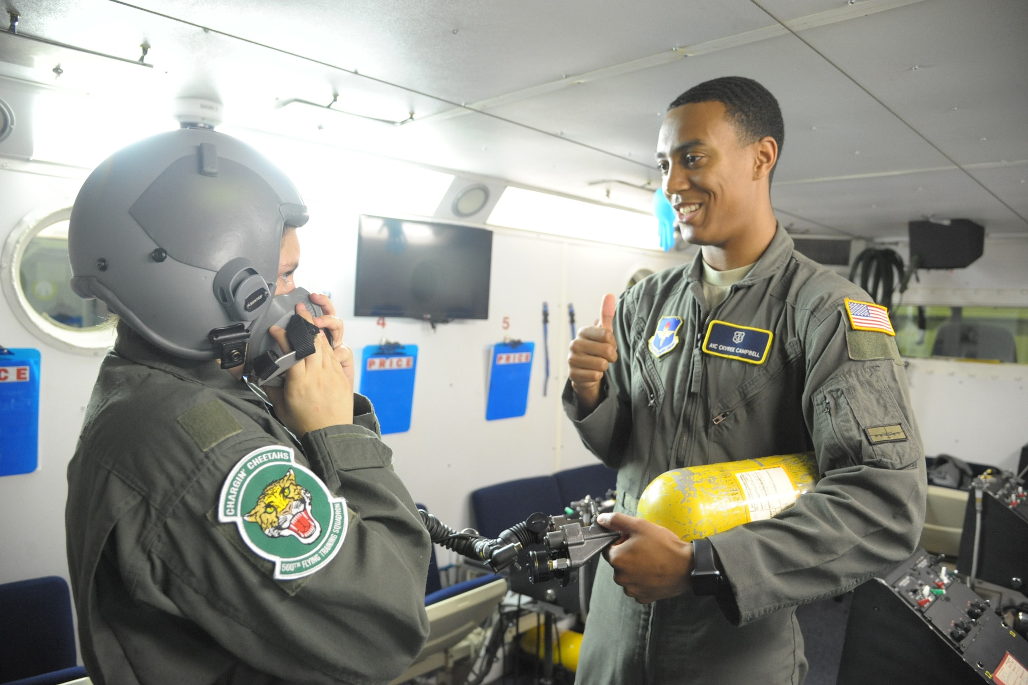 Airman 1st Class Ckyree Campbell, 59th Medical Wing aerospace physiology technician, speaks about the altitude chamber to Megan Foster, during her “Pilot for a Day” orientation June 26, 2018, at Joint Base San Antonio-Randolph, Texas.  The "Pilot for a Day" program invites children of all ages, military or civilian, to be guests of the 12th Flying Training Wing and its flying squadrons for an entire day. In so doing, the 12th FTW strives to give each child a special day and a break from the challenges they may face.  (U.S. Air Force photo by Joel Martinez/Released)