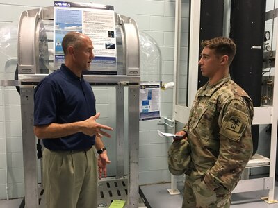 Naval Surface Warfare Center Panama City Division welcomed aboard Joint Service Diving Officers for a tour of facilities to learn about diving capabilities for their missions and training on June 29, 2018. John Kelly, left, branch head of diving fleet systems discusses use of the diver ascent capsule with 2nd Lt Maximilian Krieg, right, U.S. Army. The Joint Diving Officer Course is designed to provide initial pipeline training for officers assigned to a diving command. This course trains U.S. Navy, Army, and Coast Guard officers to safely and effectively perform as a diver, dive team member, Diving Supervisor, and a Diving Officer in accordance with the U. S. Navy Diving Manual and approved technical manuals. U.S. Navy Photo by Susan H. Lawson.