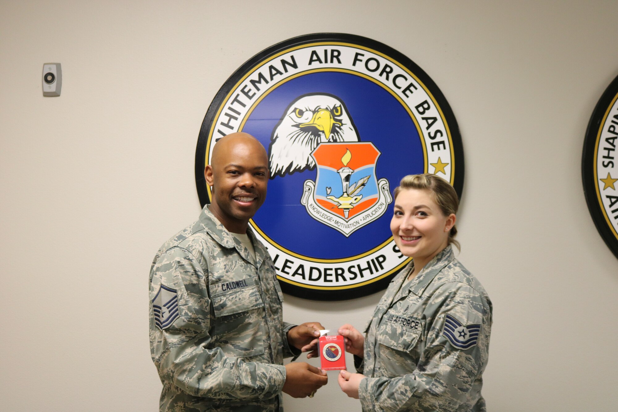 U.S. Air Force Master Sgt. Dennis Caldwell Jr., the current Airman Leadership School commandant, presents Tech. Sgt. Candace Caudill, from the 509th Medical Group, with the Air Force Professional Military Education badge for her selection as the newest ALS instructor at Whiteman Air Force Base, Missouri, on April 26, 2018. Caudill will lead her first class, Class 18-F, on Aug. 1, 2018. (Courtesy photo by Staff Sgt. Erik Johannes)