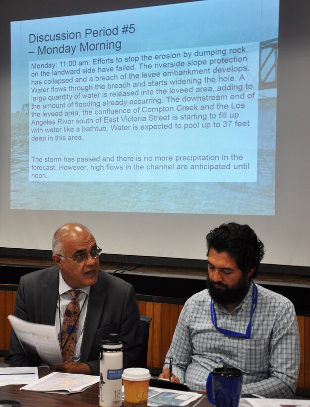 Juan Zuniga, a civil engineer with the U.S. Army Corps of Engineers Los Angeles District, right, listens to one of his team mates from Los Angeles County during a flood-risk tabletop exercise June 21 at the LA County Department of Public Works.