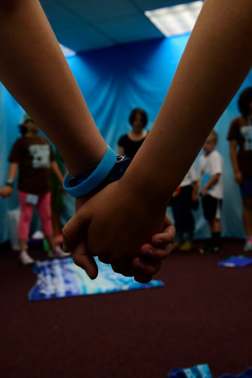 Children hold hands during a closing prayer June 29, 2018 at Fairchild Air Force Base, Washington. Children participated in four daily activity stations during the five-day Vacation Bible School, learning about the teachings of the bible. These lessons also gave the military children important tools to build upon their spiritual resilience in the face of numerous challenges and stressors they encounter on a near daily basis. (U.S. Air Force photo/Staff Sgt. Nick Daniello)