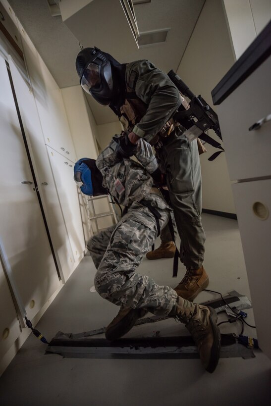 A U.S. Marine Corps Marine from the Provost Marshal’s Office special reaction team helps a simulated hostage during an active shooter training exercise June 25, 2018, at Ryukyu Middle School, Kadena Air Base, Japan. The exercise enabled 18th Security Forces Squadron defenders to work with a U.S. Marine Corps special reaction team and the Kadena Fire Department to hone their skills. (U.S. Air Force photo by Staff Sgt. Micaiah Anthony)
