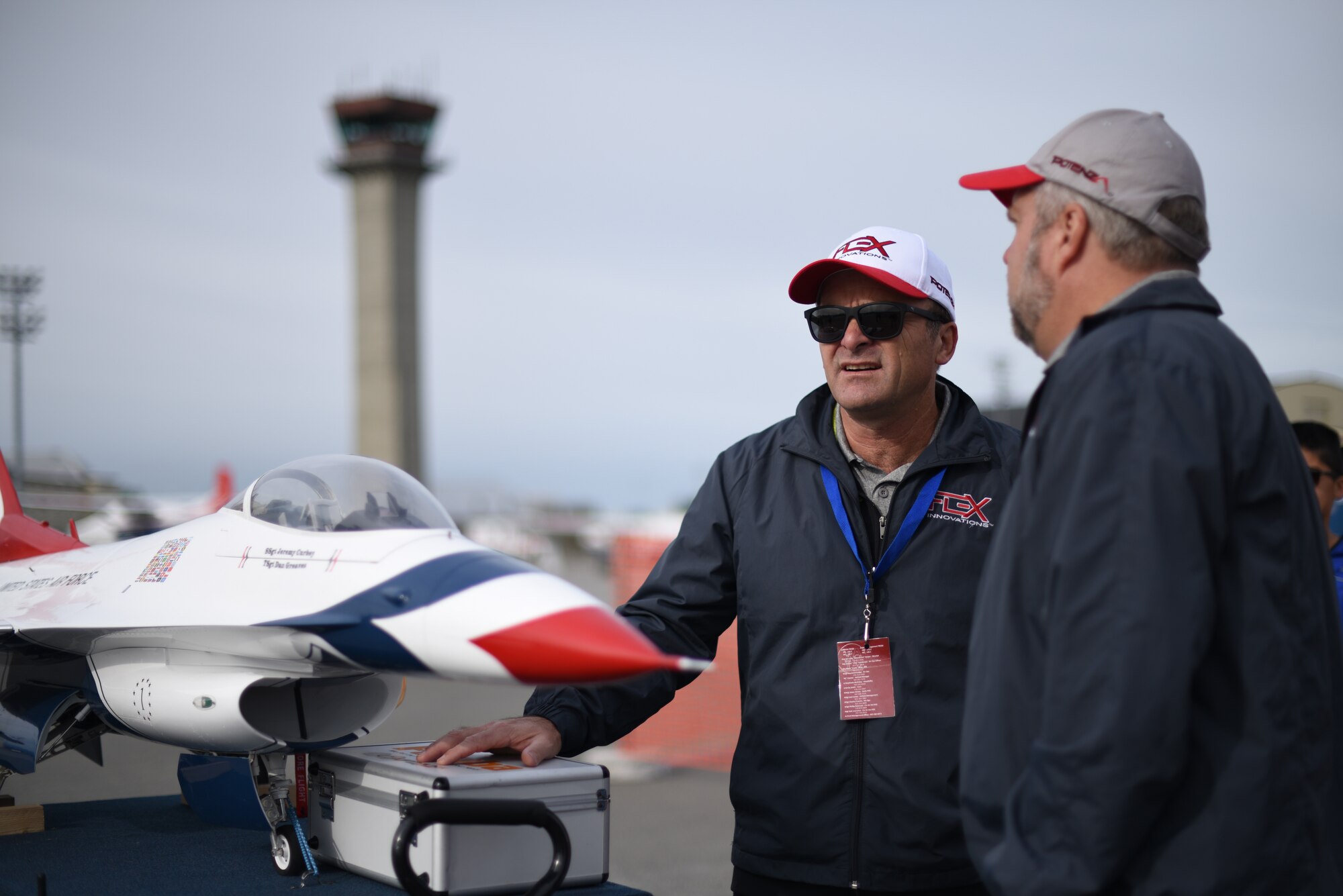 Quique Somenzini, unmanned aircraft systems pilot, and Dave Ribbe, maintainer, discuss the flight demonstration plan for the F-16QQ PNP model jet during the Arctic Thunder Open House Special Needs and Department of Defense Family Day at Joint Base Elmendorf-Richardson, Alaska, June 29, 2018. During the biennial open house, JBER opens its gates to the public and hosts multiple performers including the U.S. Air Force Thunderbirds, JBER Joint Forces Demonstration and the U.S. Air Force F-22 Raptor Demonstration Team.