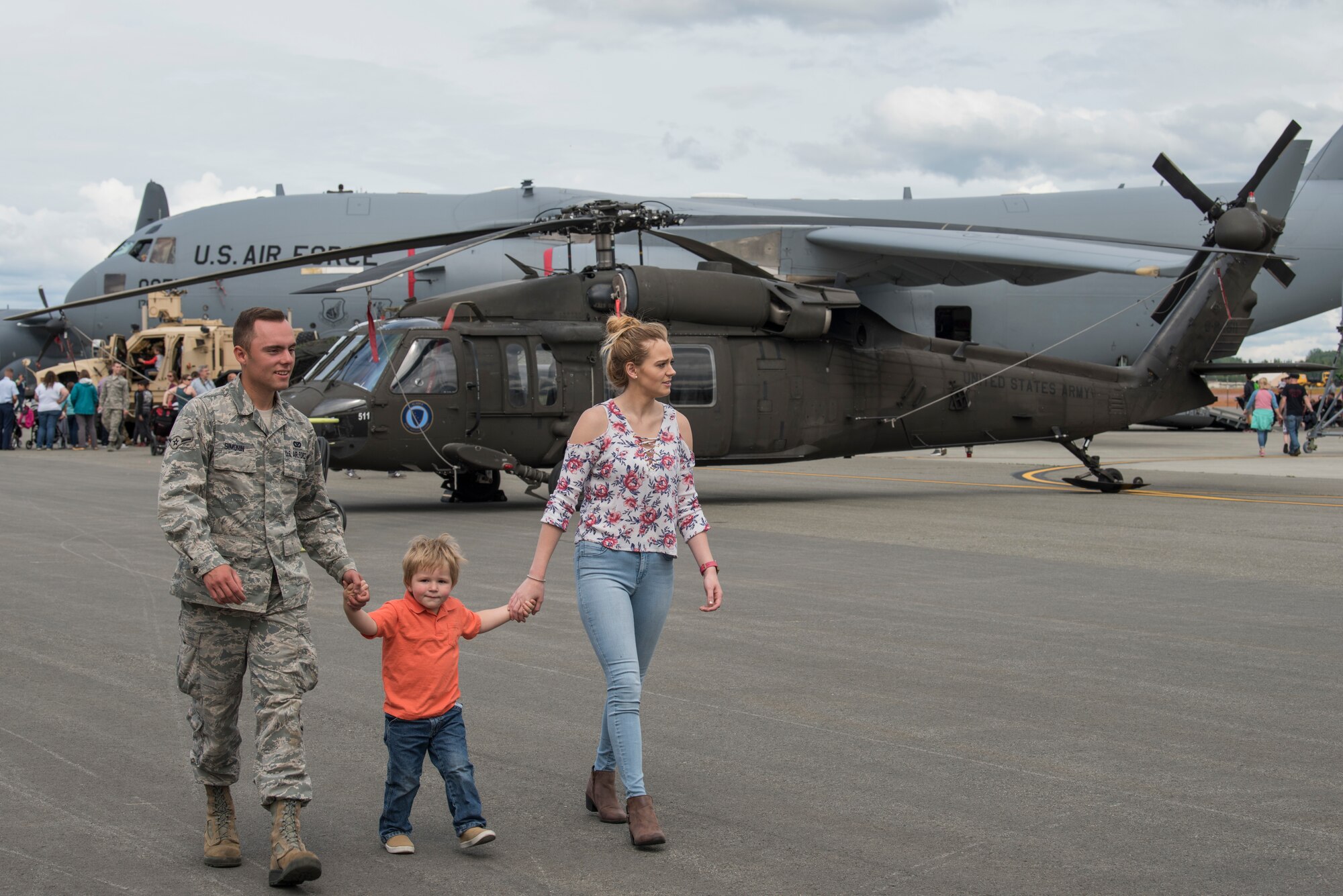 U.S. Air Force Airman Nicholas Simonin, a 773rd Civil Engineer Squadron Heavy Repair Shop technician walks with his son Bentley, 2, and wife Hailey, as they look at static displays during the Arctic Thunder Open House Special Needs and Department of Defense Family Day at Joint Base Elmendorf-Richardson, Alaska, June 29, 2018. During the biennial open house, JBER opens its gates to the public and hosts multiple performers including the U.S. Air Force Thunderbirds, JBER Joint Forces Demonstration and the U.S. Air Force F-22 Raptor Demonstration team.