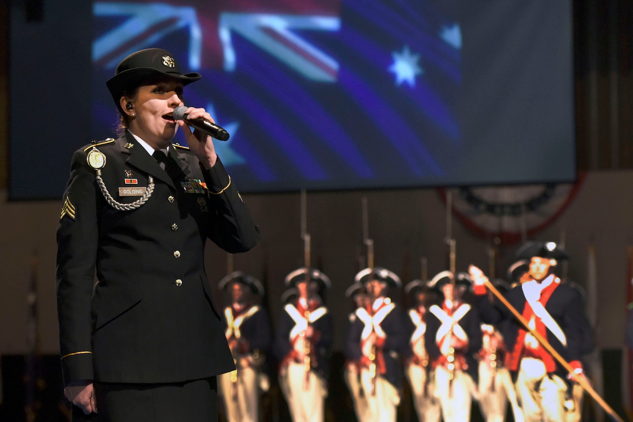 Army Sgt. Vicki Golding, a vocalist with the District of Columbia Army National Guard's 257th Army Band, sings the Australian national anthem as part of the Centenary of Mateship celebration during the Twilight Tattoo, June 27, 2018, at Joint Base Myer-Henderson Hall, Virginia. Golding, an Australian native who now lives in the U.S., also performed "The Star-Spangled Banner," and "I Am Australian" at the event, which commemorated the 100-year anniversary of the partnership between the United States and Australia established during World War I.