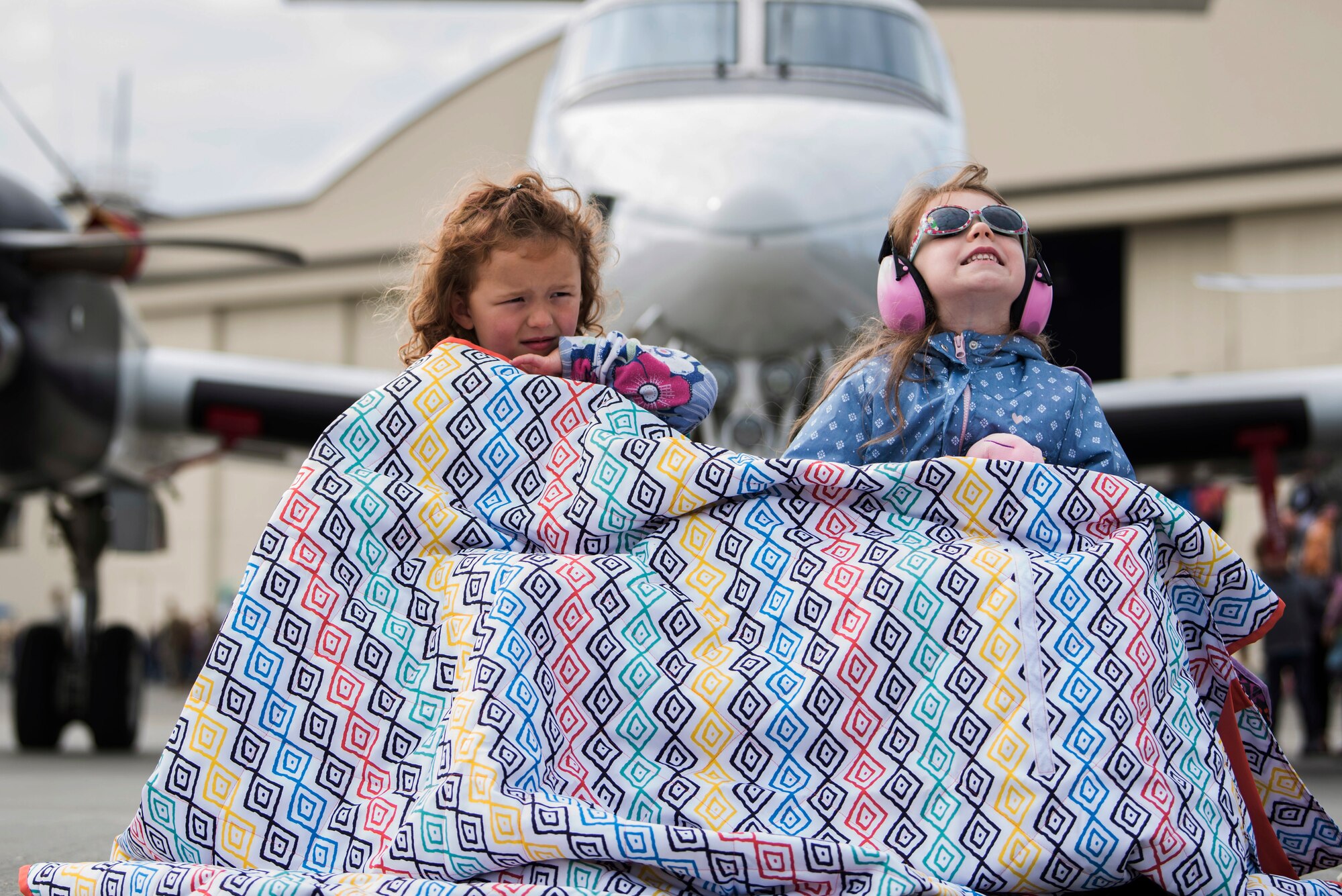 McKenzie Young (left), 5, and her cousin Brianna Bergstrom, 6, view aerial displays during the Arctic Thunder Open House on Joint base Elmendorf-Richardson, Alaska, June 30, 2018. During the biennial open house, JBER opens its gates to the public and hosts multiple performers including the U.S. Air Force Thunderbirds, JBER Joint Forces Demonstration and the U.S. Air Force F-22 Raptor Demonstration Team.