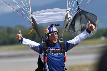 A member of the  Red Bull Air Force celebrates after parachuting onto the runway at the Arctic Thunder Open House at Joint Base Elmendorf-Richardson, Alaska, June 30, 2018. During the biennial open house, JBER opens its gates to the public and hosts multiple performers including the U.S. Air Force Thunderbirds, JBER Joint Forces Demonstration and the U.S. Air Force F-22 Raptor Demonstration Team.