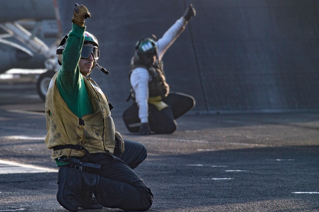 Catapult crewmen signal the plane director during flight operations on the aircraft carrier USS Carl Vinson.