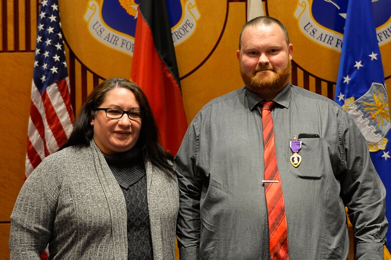 Judson Rackley, U.S. Air Forces in Europe-Air Forces Africa video operations center communications engineer, right, poses for a picture with his wife, Audrea, after receiving the Purple Heart on Ramstein Air Base, Germany, Feb. 27, 2018. Rackley previously served in the U.S. Army, where he took part in missions in Afghanistan. (U.S. Air Force photo by Senior Airman Joshua Magbanua)