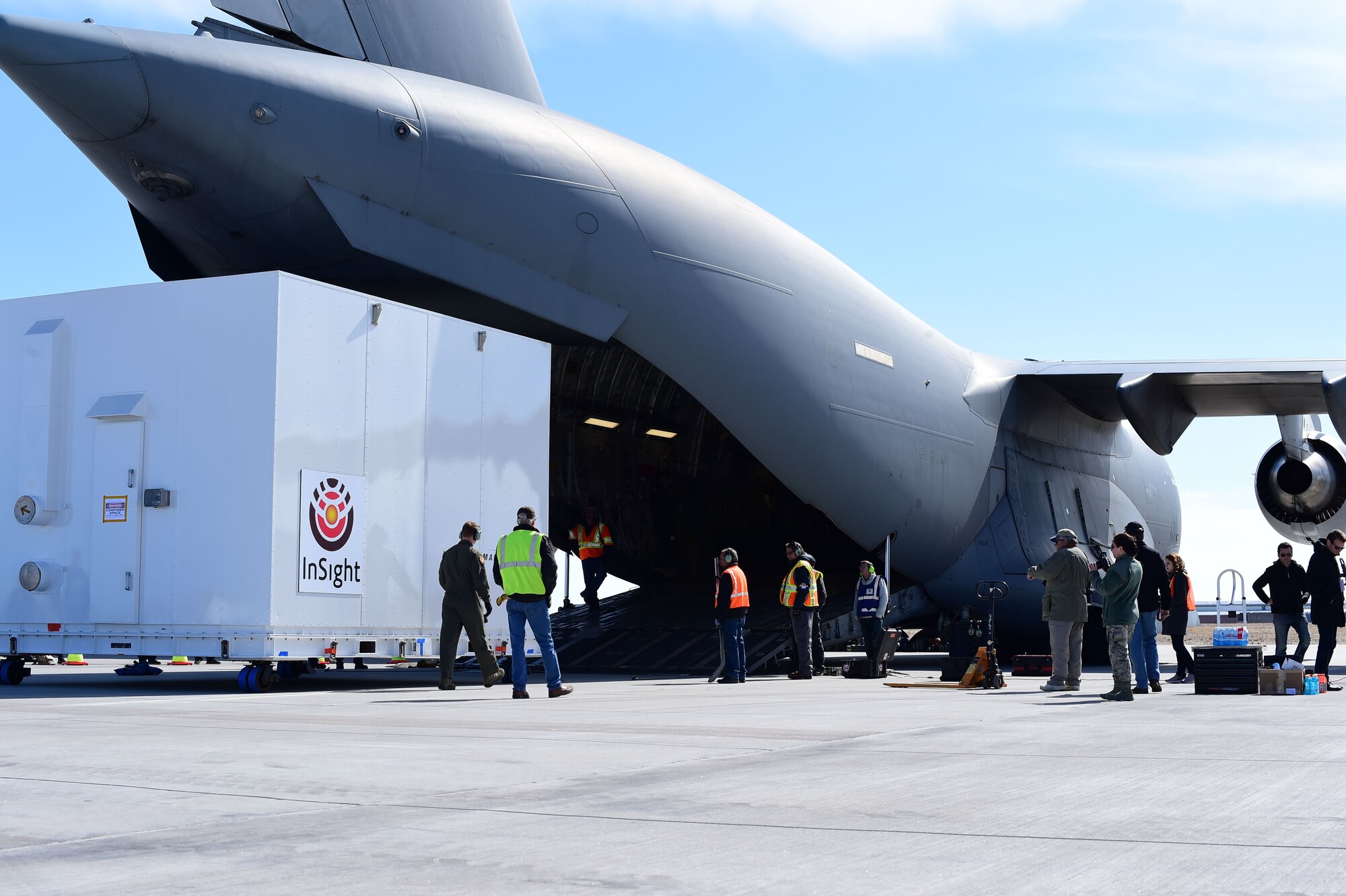 Members from Lockheed Martin carefully observe the Interior Exploration using Seismic Investigations, Geodesy and Heat Transport lander being loaded onto a Boeing C-17 Globemaster III Feb. 28, 2018, on Buckley Air Force Base, Colorado. The measurements taken by the lander while on the surface of Mars will give scientists more insight into the origins of our planets and solar system. (U.S. Air Force photo by Senior Airman Luke W. Nowakowski)