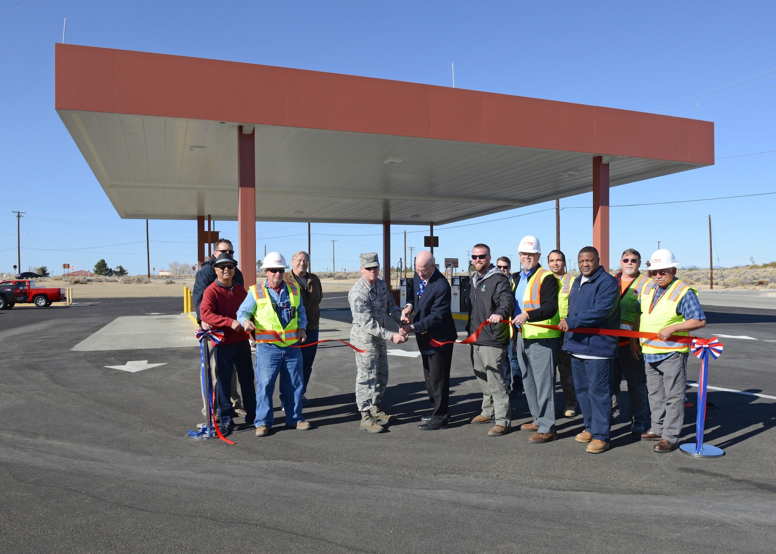 Center: Chief Master Sgt. Daniel Thompson, 412th Mission Support Group superintendent, and James Judkins, 412th Civil Engineer Group director, cut the ceremonial ribbon to celebrate the completion of major repairs and upgrades to the main base military gas station at Edwards Feb. 26. The completion of the project is the last of nine projects funded by the DLA for repairs and upgrades to facilities on Edwards. (U.S. Air Force photo by Kenji Thuloweit)