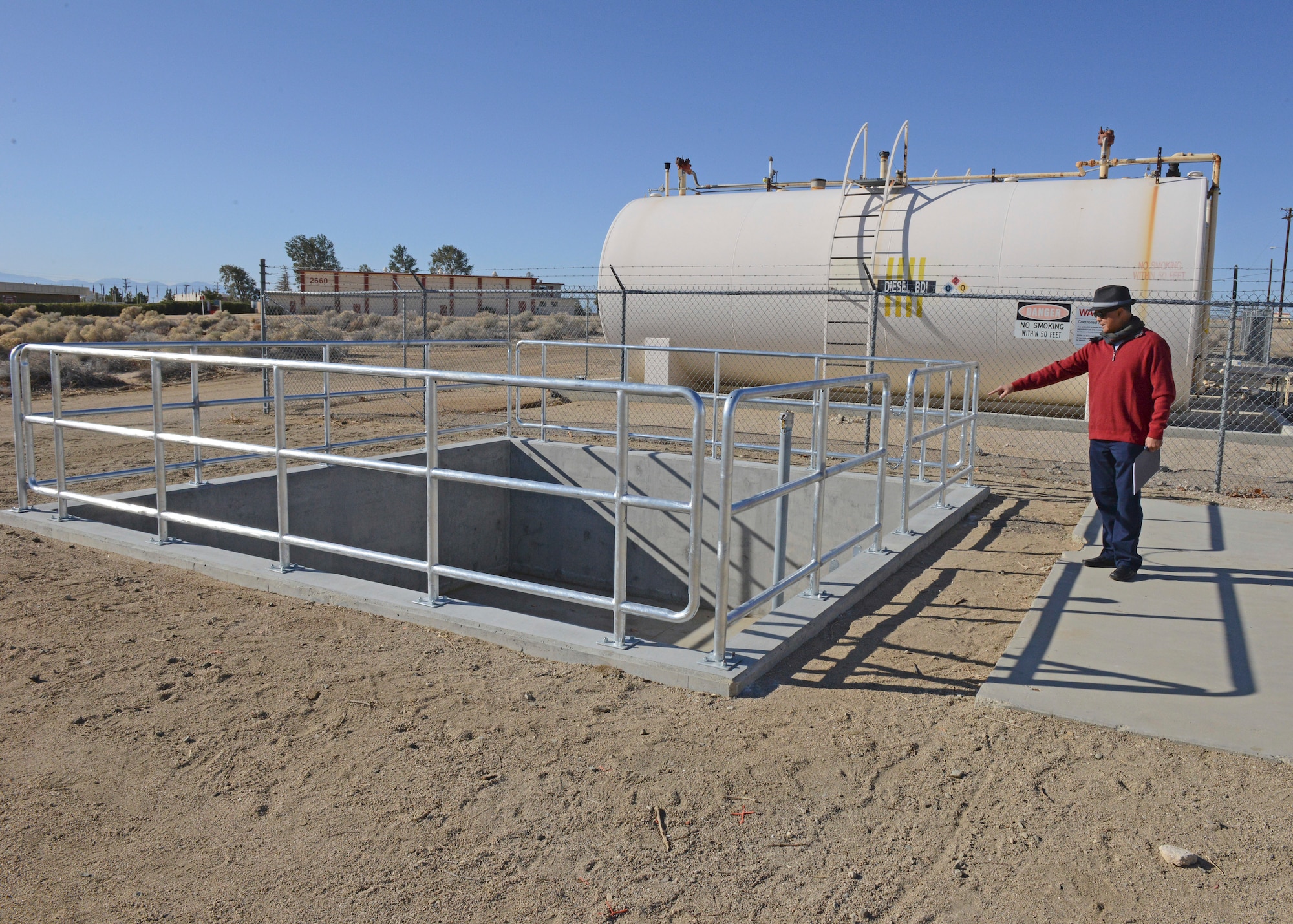 Jose Delavega, 412th Civil Engineer Group civil engineer, stands next to a new isolation pit to contain accidental fuel spills at the fuel transfer area at the main base military gas station Feb. 26. (U.S. Air Force photo by Kenji Thuloweit)