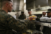 SSgt Anthony W. Oliva, SSgt Wade W. Mayhew, and GySgt Edward Dominguez (From left to right), Motor Transport Instructors, assist serving meals for students on the Marine Corps 242nd Birthday at Fort Leonard Wood, MO Nov. 10th, 2017. By leading by example, the Instructors recognize the students as future leaders of the Marine Corps. (U.S. Marine Corps photo by Sgt. Teng Yang)