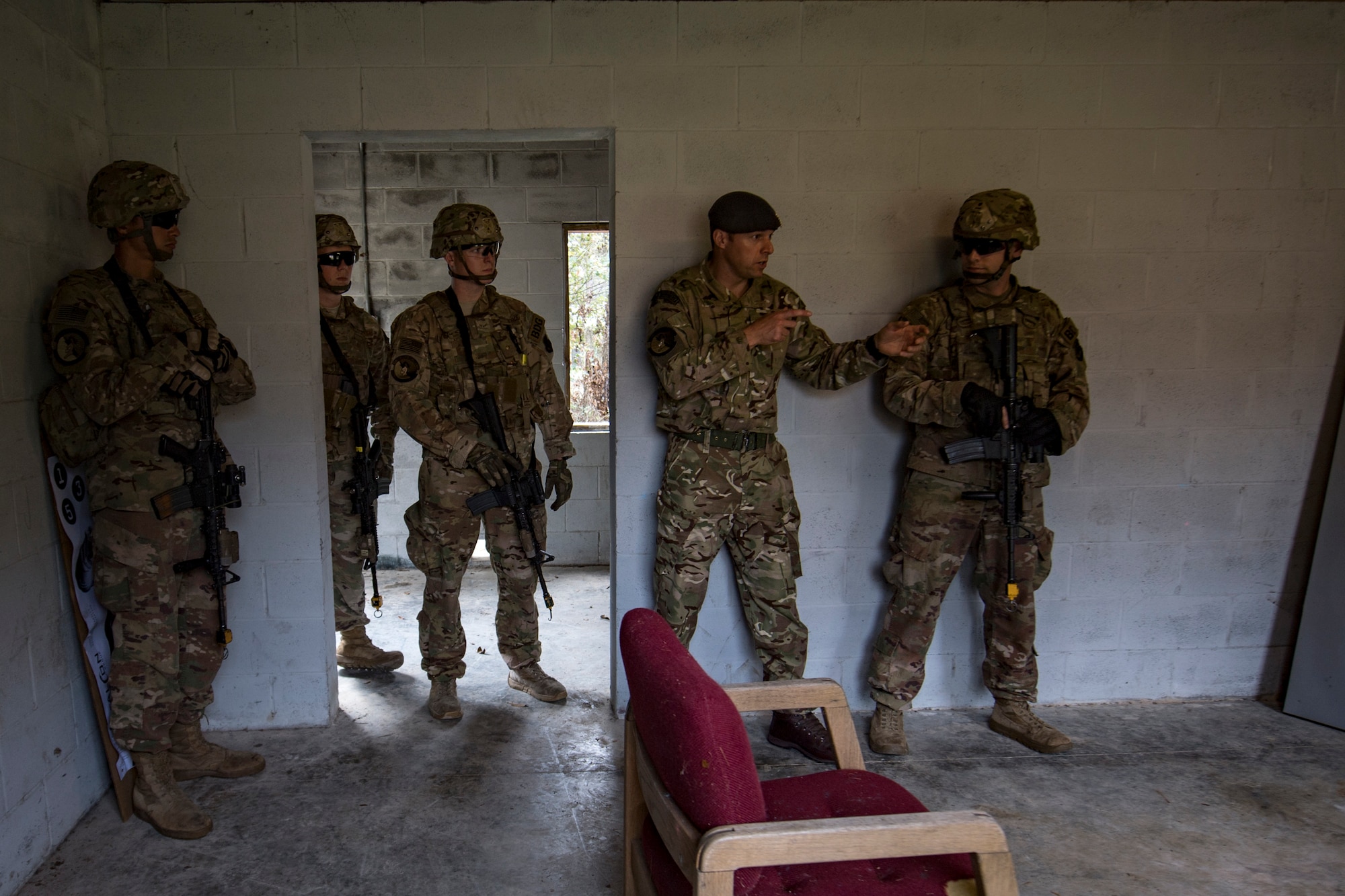 A member of the British Royal Air Force shares tactical points with Airmen from the 824th Base Defense Squadron during close-quarters battle training, Feb. 28, 2018, at Moody Air Force Base, Ga. The 820th Base Defense Group welcomed a member of the British Royal Air Force to embed into multiple training situations to help strengthen combined operations between U.S. and British forces. (U.S. Air Force photo by Senior Airman Daniel Snider)