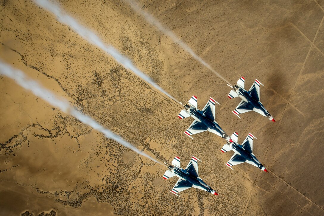 Four Thunderbird pilots perform the diamond roll maneuver during training.