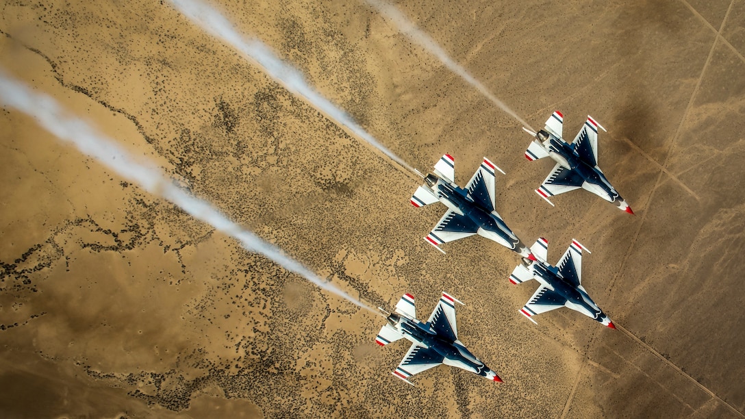Four Thunderbird pilots perform the diamond roll maneuver during training.