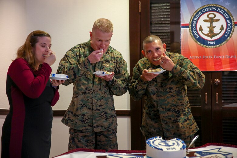 Elizabeth Moore, left, Brig. Gen. Paul Rock Jr., center, and Master Sgt. Aaron Matura take a bite of cake during the Navy-Marine Corps Relief Society Active Duty Fund Drive kick off Feb. 27 aboard Camp Foster, Okinawa, Japan. The Active Duty Fund Drive funds programs offered through the NMCRS like the budget for baby classes and providing interest free loans.  Moore is the director of the Navy-Marine Corps Relief Society, Okinawa. Rock is the commanding general of Marine Corps Installations Pacific-Marine Corps Base Camp Butler, Japan. Matura is the coordinator for the Active Duty Fund Drive. (U.S. Marine Corps photo by Pfc. Nicole Rogge)