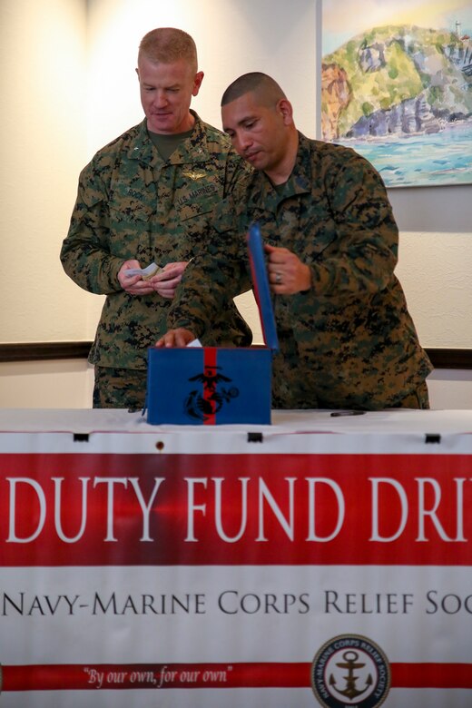 Brig. Gen. Paul Rock Jr., left, and Master Sgt. Aaron Matura prepare the donation box during the Navy-Marine Corps Relief Society Active Duty Fund Drive kick off Feb. 27 aboard Camp Foster, Okinawa, Japan. The Active Duty Fund Drive funds programs offered through the NMCRS like the budget for baby classes and providing interest free loans.  Rock is the commanding general of Marine Corps Installations Pacific-Marine Corps Base Camp Butler, Japan. Matura is the coordinator for the Active Duty Fund Drive. (U.S. Marine Corps photo by Pfc. Nicole Rogge)