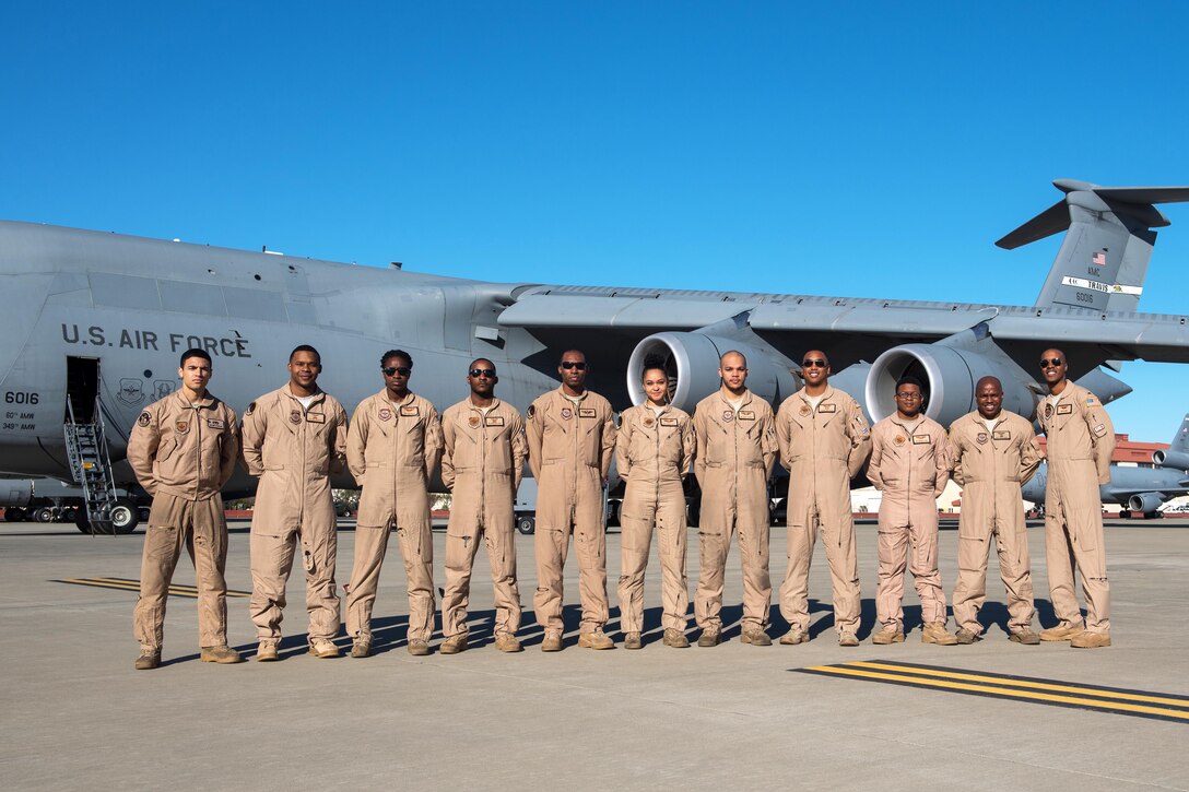 Airmen pose for a group photograph in front of a C-5M Super Galaxy aircraft.