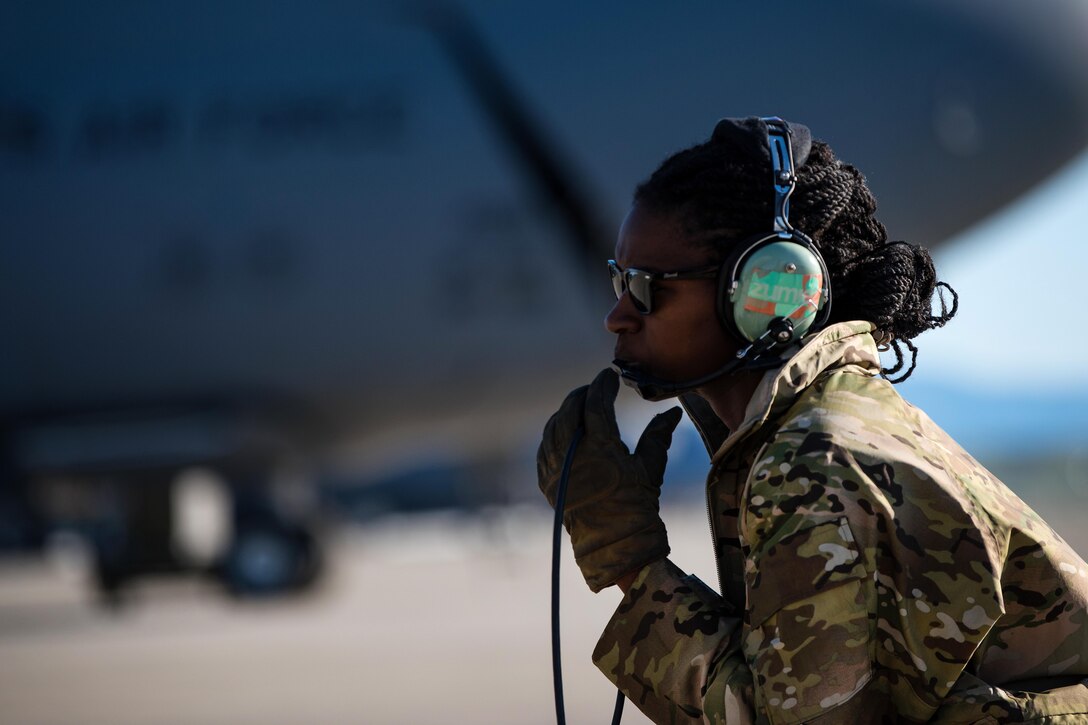 An airman talks with the crew chief while conducting pre-flight inspections.
