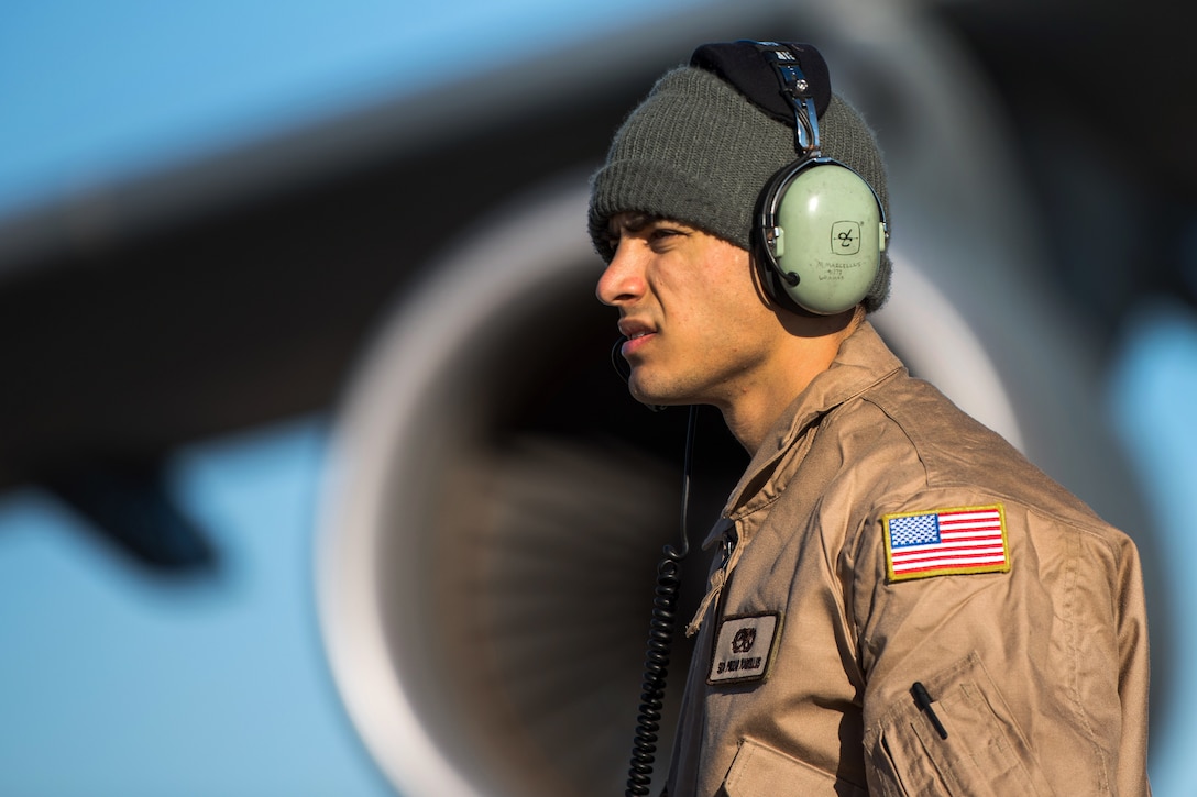 An airman talks to the flight engineer while conducting pre-flight inspections.