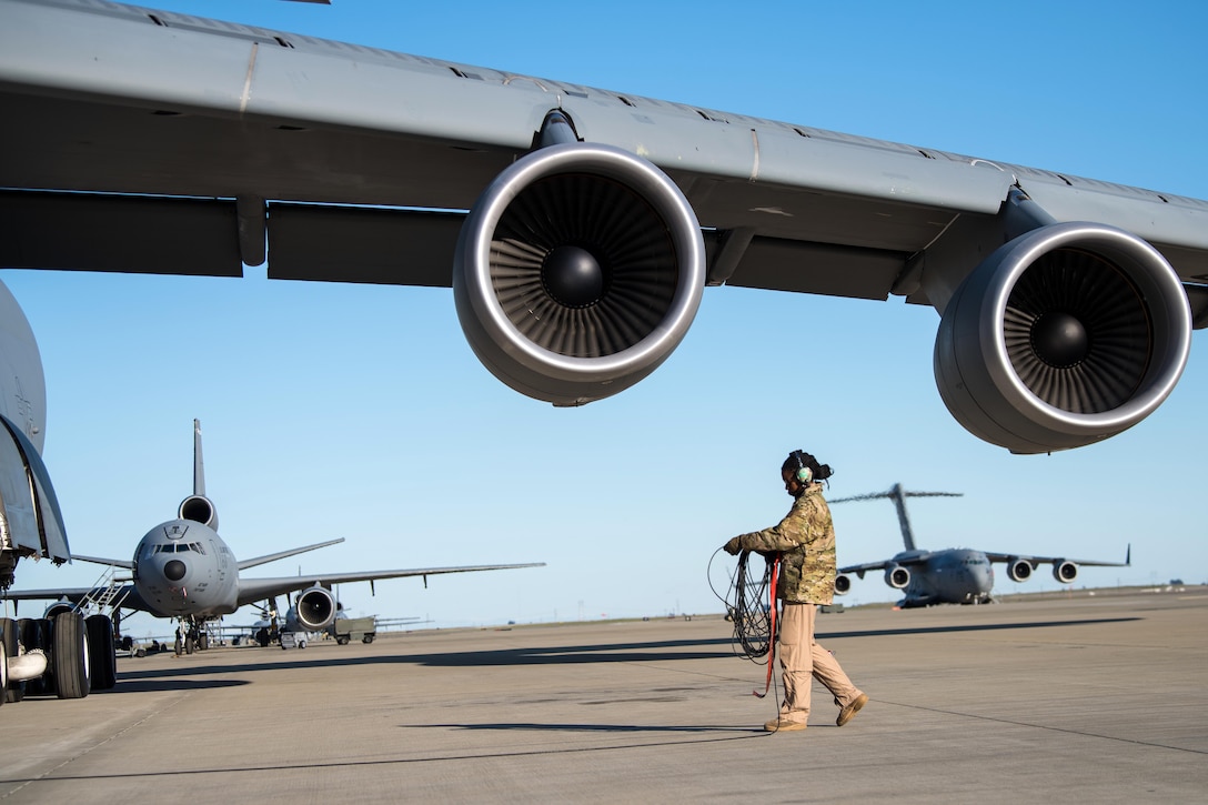 An airman recovers communication cable after conducting pre-flight inspections.