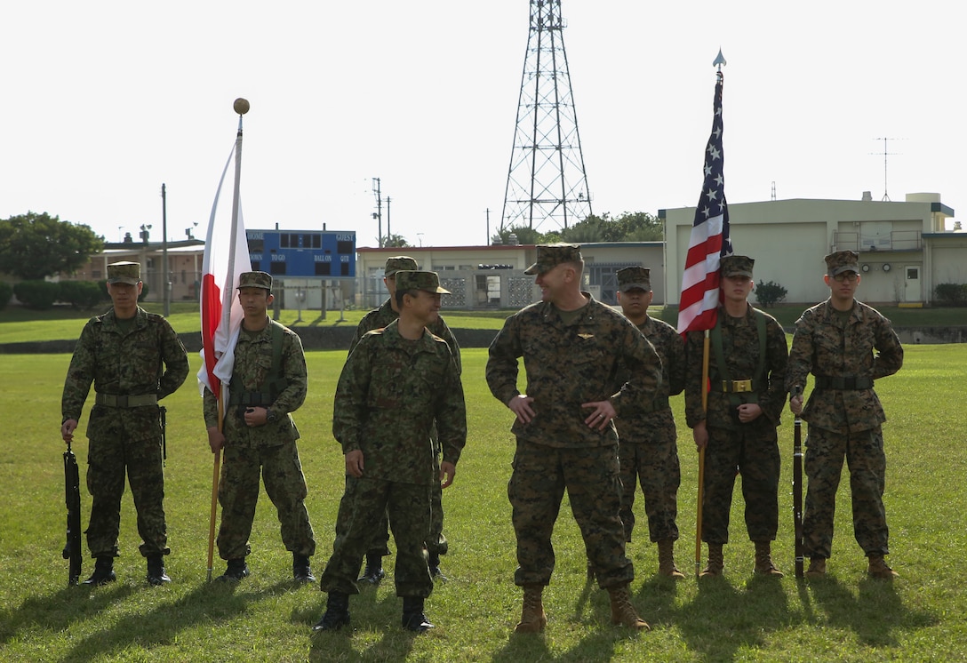 Brigadier General Christopher A. McPhillips, Commanding General, 3D Marine Expeditionary Brigade, and Major General Shinichi Aoki, Deputy Chief of Staff, Japan Ground Self-Defense Force Western Army, stand side by side at Camp Cortney, Okinawa, Japan, December 5, 2017.