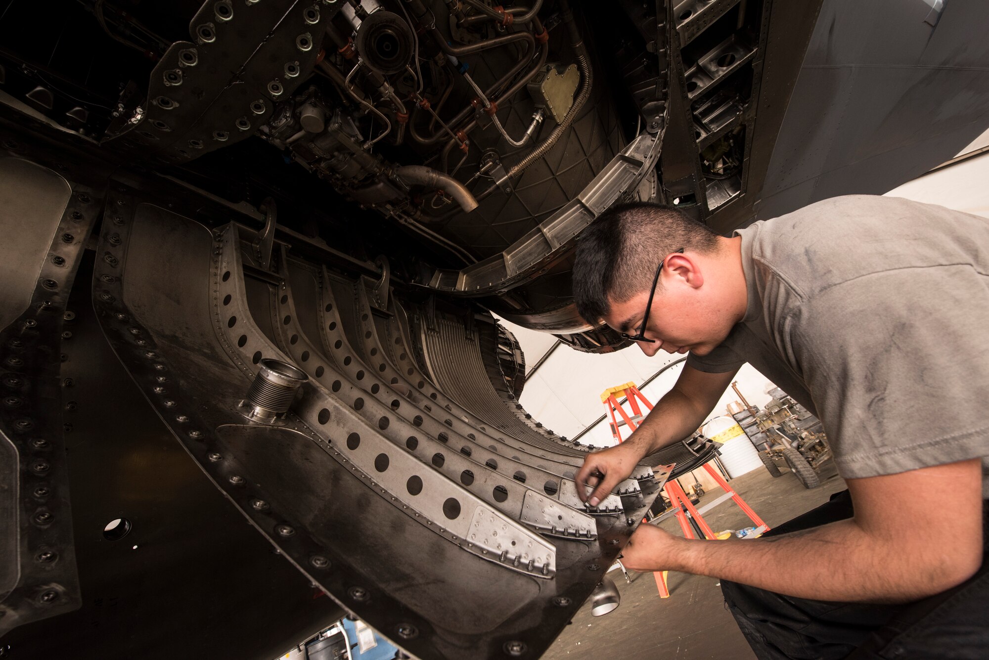 Airman 1st Class Kyle Segura, an F-15E Strike Eagle maintainer assigned to the 332d Expeditionary Maintenance Squadron, inspects components beneath an F-15E Strike Eagle during phase maintenance March 1, 2018, at an undisclosed location. Because many Strike Eagles have been in service for 30 years or more, phase maintenance is an important opportunity to inspect and replace aircraft systems from the ground up. (U.S. Air Force photo by Staff Sgt. Joshua Kleinholz)