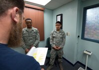 Brent Brian, a Fitness Assessment Center (FAC) lead assigned to the 97th Force Support Squadron, briefs two U.S. Air Force Airmen on the duties and responsibilities of being a Physical Training Leader, March 1, 2018, at Altus Air Force Base, Okla.