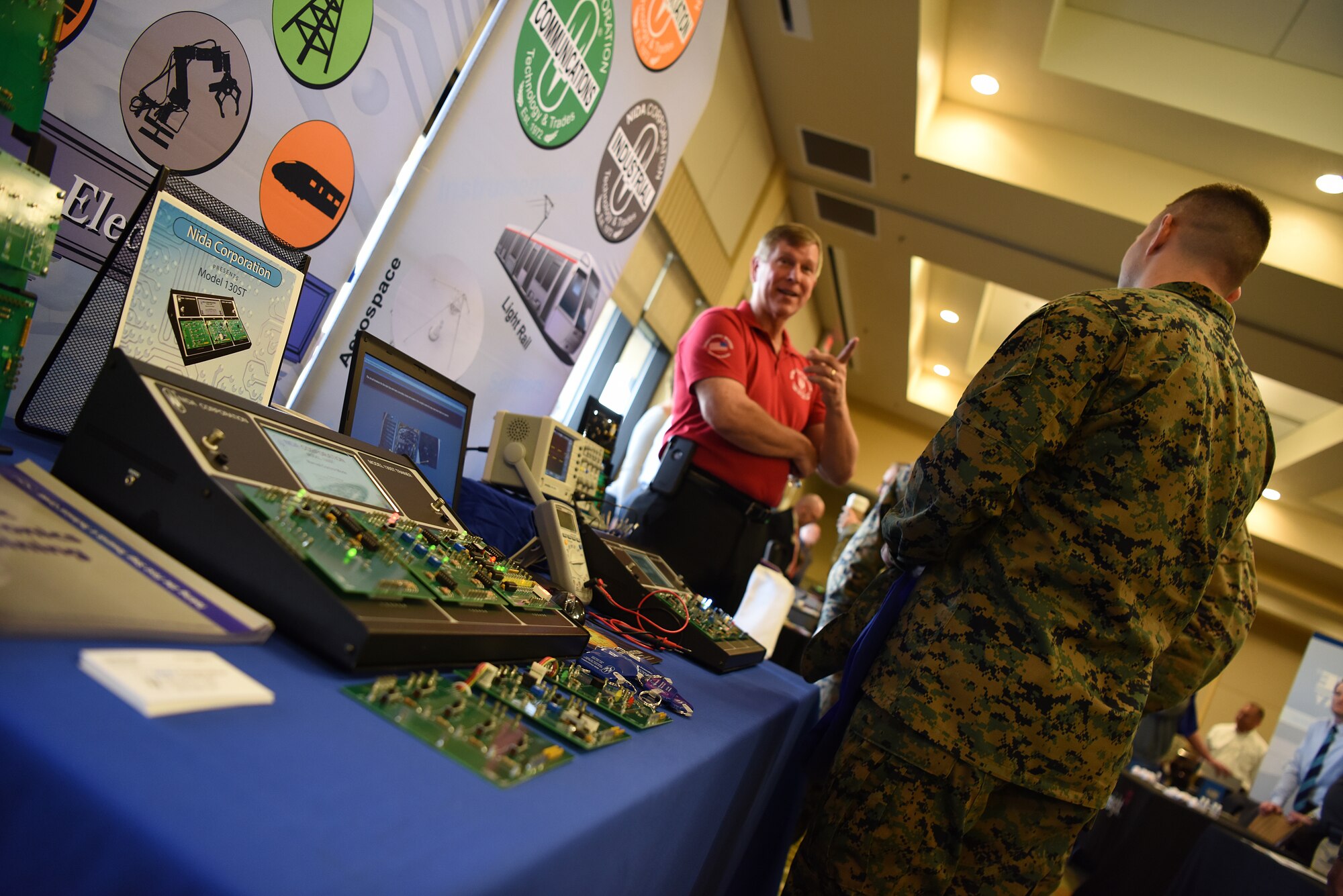 Jana Asplund, Nida Corporation Technical Specialist, talks to Keesler Marine Detachment Marines about products during the 2018 Keesler Technology Expo at the Bay Breeze Event Center Feb. 27, 2018, on Keesler Air Force Base, Mississippi. The expo was hosted by the 81st Communications Squadron and was free to all Defense Department, government and contractor personnel with base access. The event was held to introduce military members to the latest in technological advancements to bolster the Air Force’s capabilities in national defense. (U.S. Air Force photo by Airman 1st Class Suzanna Plotnikov)