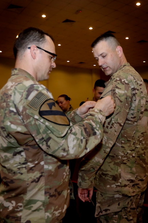 A member of the Kansas National Guard’s 635th Regional Support group from places the U.S. Army Central patch on Chief Warrant Officer 3  Jesse Boyd, a member of the Massachusetts National Guard’s 151st  Regional Support Group from Foxboro, Mass. February 28. The two were  participating in a change of authority ceremony where the 151st  replaced the 635th, beginning only the second ever rotation of  National Guard Soldiers to take on the support mission for U.S. Army  Central, which commands the U.S. Army’s land forces in the Middle East.