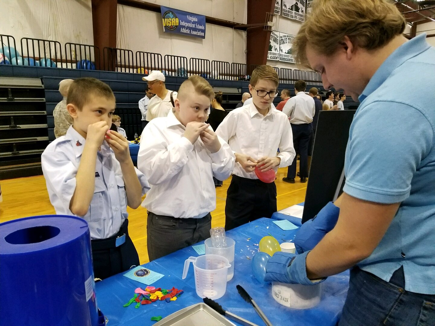 IMAGE: FREDERICKSBURG, Va. - Navy engineer Josh Taylor conducts a liquid nitrogen demonstration with students at the science, technology, engineering and mathematics (STEM) Summit hosted by the Fredericksburg Academy, Feb. 24. Taylor - a Naval Surface Warfare Center Dahlgren Division (NSWCDD) STEM mentor - and the students discussed the Ideal Gas Law, and how it relates different attributes of a fluid. In the picture, they are exposing the inflated balloons to liquid nitrogen and observing that the volume of air inside the balloons decreased as the temperature decreased. Taylor and the students then discussed and demonstrated how changes in temperature could be used to produce kinetic energy, and how temperature changes could affect the behavior of materials. For example, they made flowers shatter like glass, tennis balls that would not bounce, and rubber bands that cracked. 
    "I really enjoyed talking to students and answering their questions, not just about basic principles, but introducing concepts that one doesn't normally explore until college," said Taylor. "I think Dahlgren mentors play a crucial part at venues like this because we help students make a connection between ideas they learn in school and real work they could do one day. Personally, I've met many students who were inspired by events like this to engage the sciences and applied sciences not just as homework - but as a vocation."