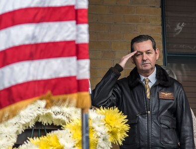 Retired Rear Adm. David "Deke" Philman salutes the flag during the National Anthem at the ceremony celebrating the first military flight, held at the Foulois House at Joint base San Antonio-Fort Sam Houston, March 2. Philman was the guest speaker for the event.