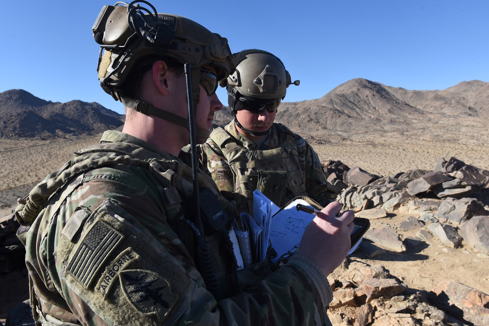 Senior Airman Nicholas Ward, left, and fellow 3d Air Support Operations Group Tactical Air Control Party specialist Airman 1st Class Jaron Maddox, records target threat areas to relay to pilots during a close-air support exercise as part of a Ft. Irwin, Calif. National Training Center rotation, Feb. 20, 2018. During the month-long rotation, 93d Air Ground Operations Wing units embedded with approximately 4,000 soldiers in the largest force-on-force live-fire exercise in the world. The 93d AGOW provided tactical air control party support to enhance interoperability for major combat operations downrange. (U.S. Air Force photo by Senior Airman Greg Nash)