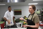 Lt. Col. Christine Edwards (right), an Army dietician, teaches couples the importance of planning out a meal and cooking together while Sgt. 1st Class Raphael Bonair, a culinary specialist with U.S. Army North (Fifth Army) and the enlisted aide to Lt. Gen. Jeffery S. Buchanan, the senior commander for ARNORTH, demonstrates pan-searing chicken thighs at the Vogel Resiliency Center at Joint Base San Antonio- Fort Sam Houston, Texas Feb. 23 during a marriage enrichment class.