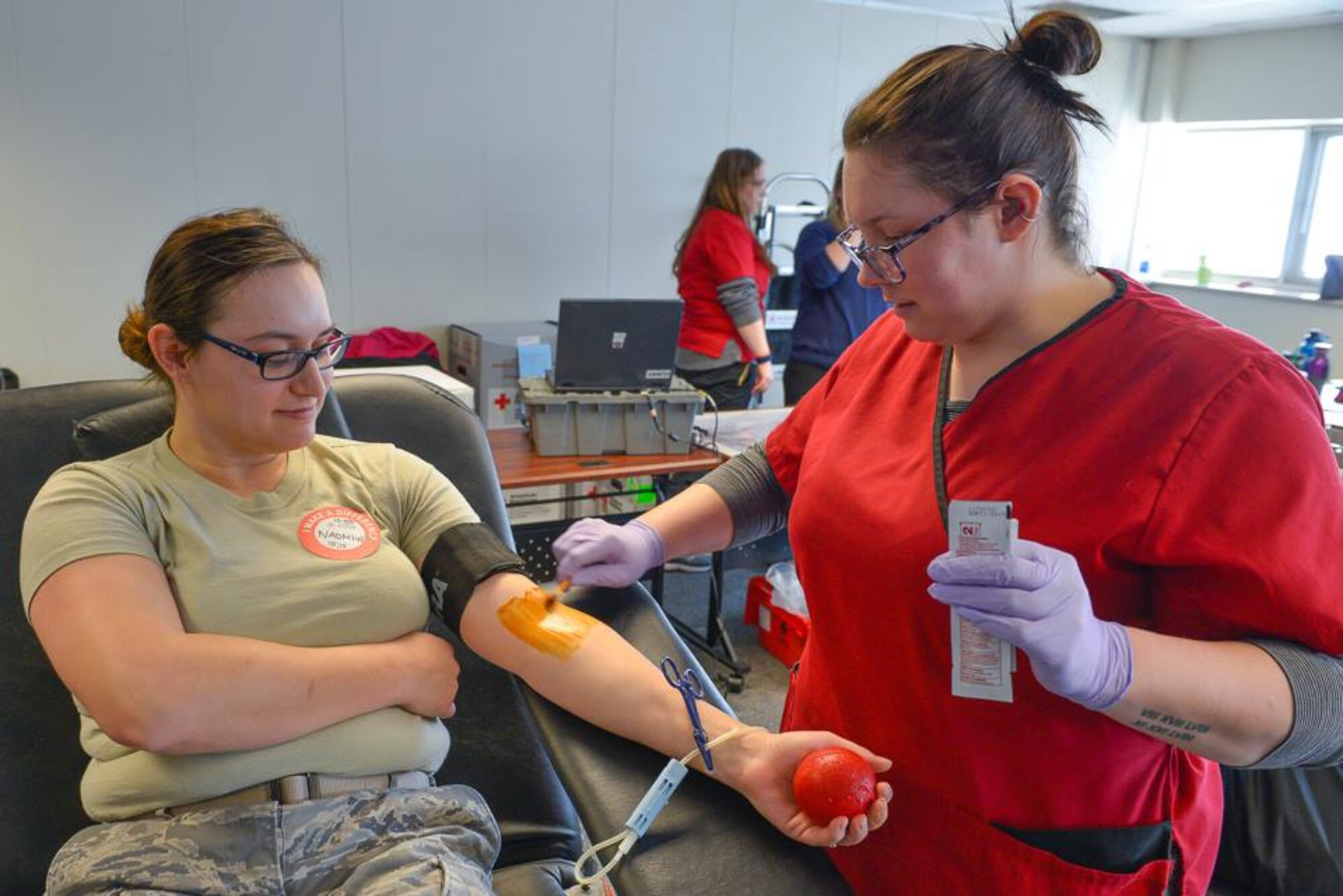 Tech. Sgt. Naomi Boushka, 934th Force Support Squadron readiness specialist, gets prepped to have her blood drawn by Brittany Klinke, North Central Red Cross phlebotomist, at the Minneapolis-St. Paul Air Reserve Station Feb. 28, 2018. The 934th Airlift Wing participated in the blood drive to help bolster local supplies of blood and plasma. (Air Force Photo/Master Sgt. Eric Amidon.)