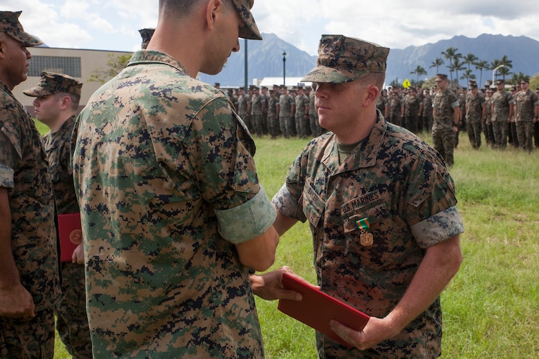 Lance Cpl. Jacob Baker, a cryptologic linguist with 3rd Radio Battalion (3rd RADBN), is presented a Navy Marine Corps Achievement Medal by Lt. Col. William Osborne, the 3rd RADBN commanding officer, Marine Corps Base Hawaii, Feb. 16, 2018. Three Marines, including Baker, conducted a late night search and rescue for a lost hiker back in January 2018. The Marines covered 10 miles up about 3000 feet in elevation under rainy conditions, eventually finding and returning back with the hiker. (U.S. Marine Corps photo by Sgt. Jesus Sepulveda Torres)