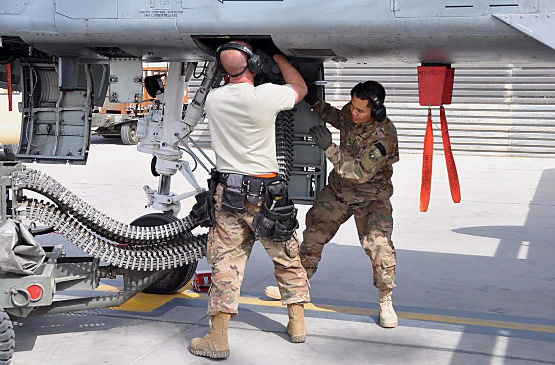Tech. Sgt. Nathan Wesley and Airman 1st Class Rey Nino Estrella, weapons loader Airmen assigned to the 303rd Expeditionary Fighter Squadron, reload the 30mm gun on an A-10 Thunderbolt II before a mission at Kandahar Airfield, Afghanistan, Feb. 10, 2018.