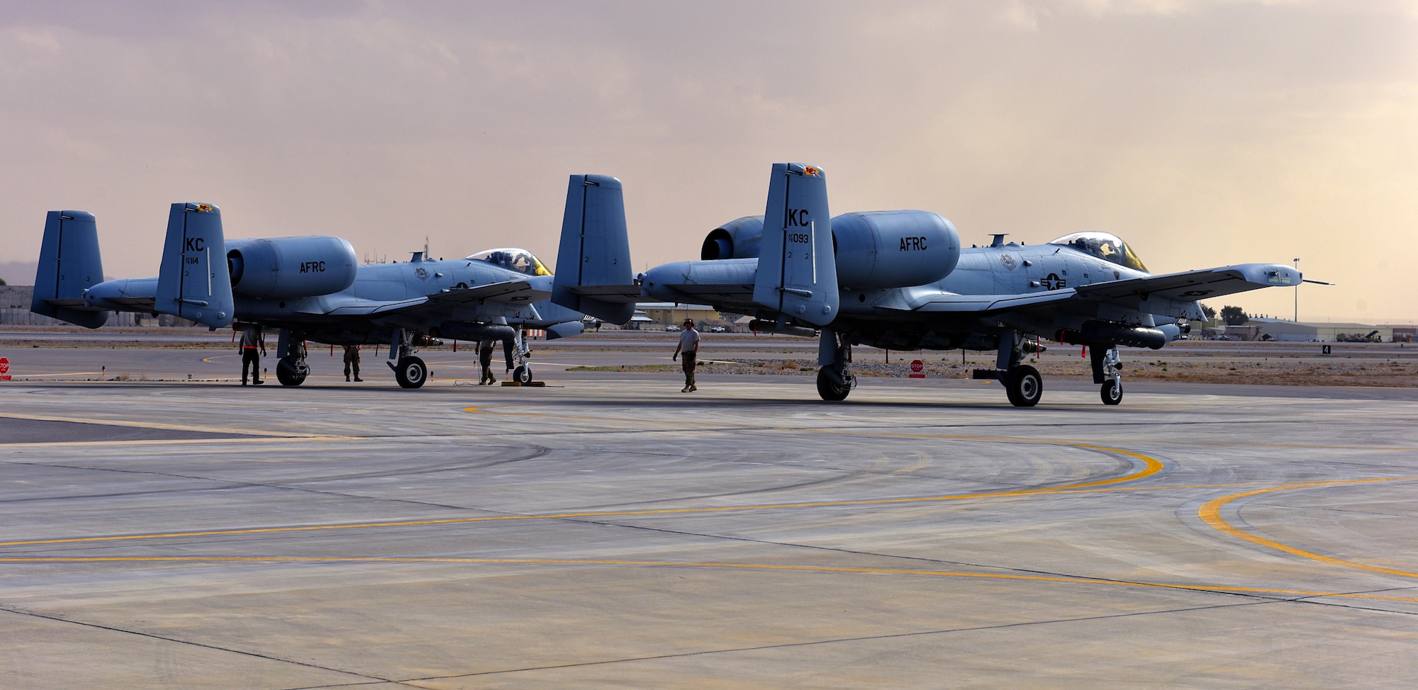 Crew chiefs and weapons Airmen assigned to the 303rd Expeditionary Fighter Squadron arm the weapons on two A-10 Thunderbolt IIs prior to takeoff at Kandahar Airfield, Afghanistan, Feb. 27, 2018.